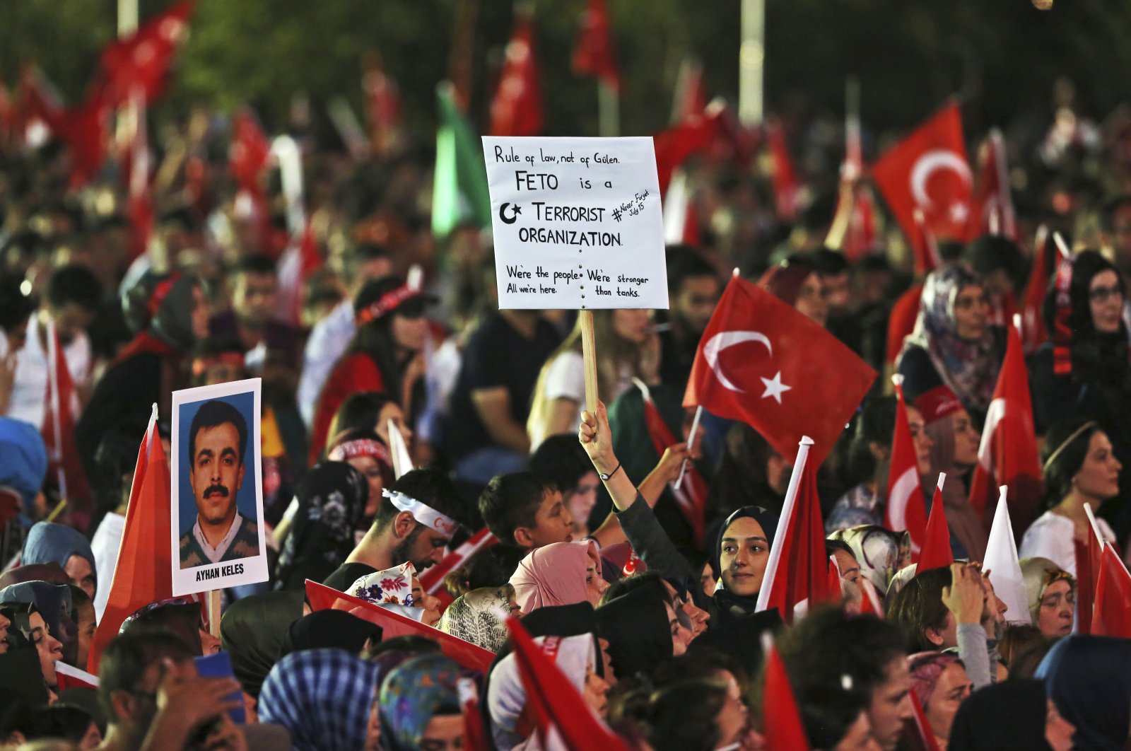 People hold placards denouncing FETÖ in a rally to mark the anniversary of the foiled coup attempt, in the capital Ankara, Türkiye, July 16, 2017. (AP Photo)