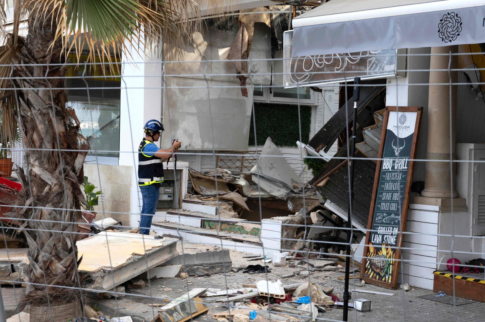 A Police officer takes images during investigation works a day after a two-storey restaurant collapsed, on Playa de Palma, Spain, May 24, 2024. (AFP Photo)