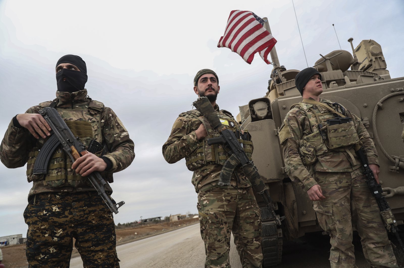 YPG terrorists and U.S. soldiers stand next to each other in Hassakeh, Syria, Feb. 8, 2022. (AP Photo)