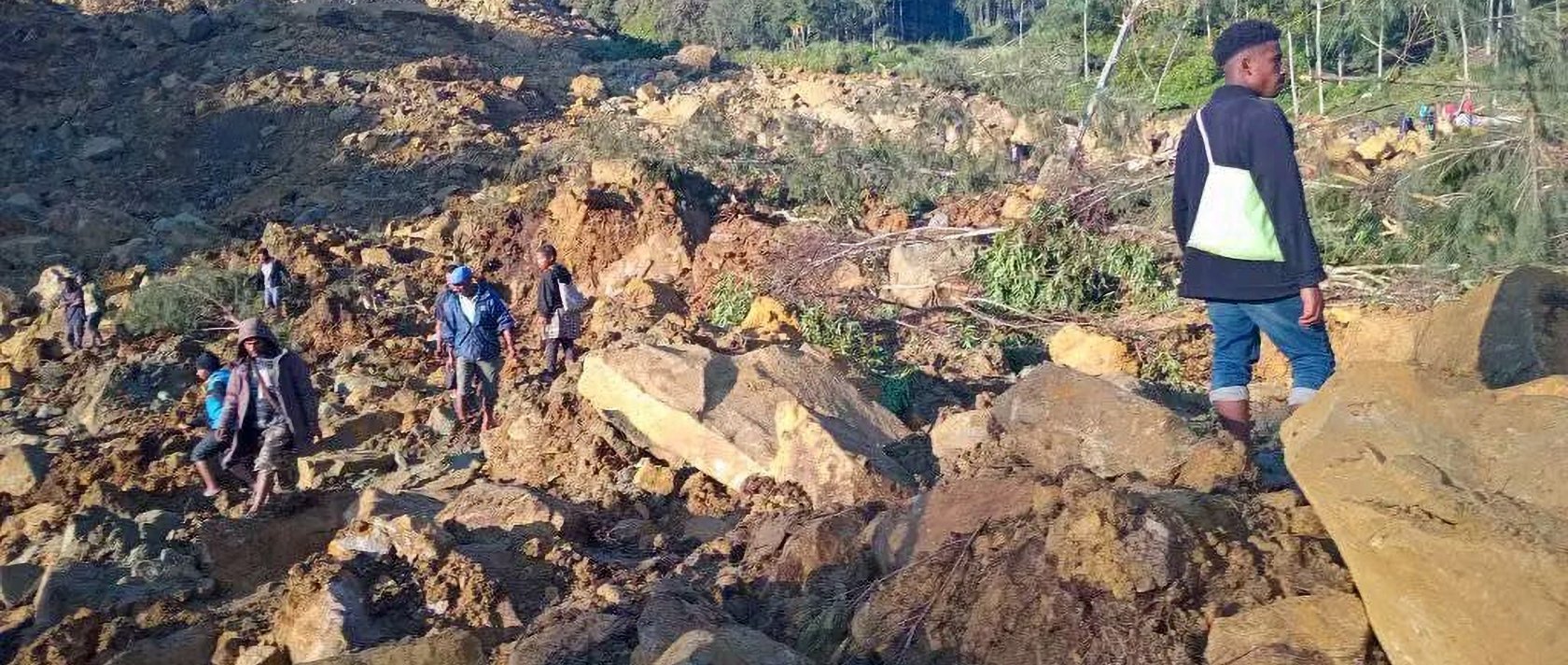 People walk with their belongings in the area where a landslide hit the village of Kaokalam, Enga province, Papua New Guinea, May 24, 2024. ()
