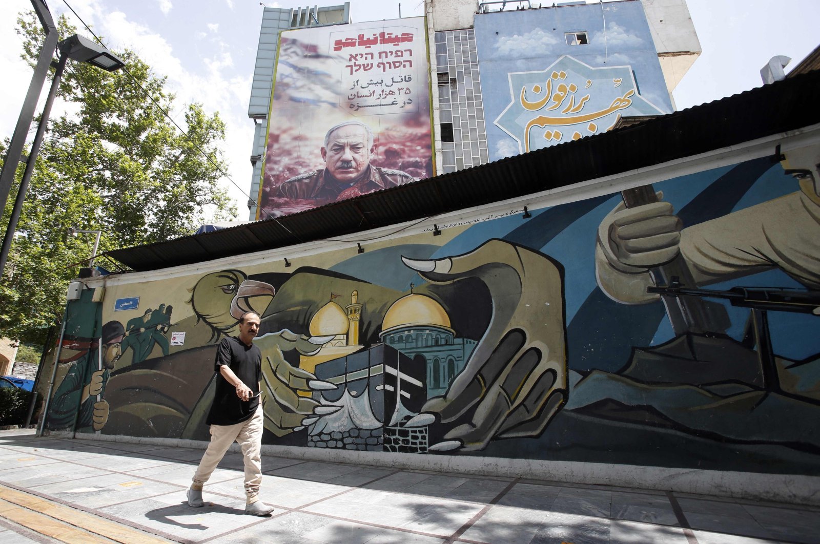 Iranians walk past an anti-Israeli billboard bearing the portrait of Israel&#039;s Prime Minister Benjamin Netanyahu, Tehran, Iran, May 12, 2024. (AFP Photo)