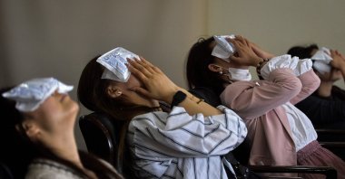 People using cold compresses on their eyes after undergoing cosmetic eyelid surgery at a hospital in Shenyang, northeastern Liaoning province, China, May 21, 2024. (AFP Photo)