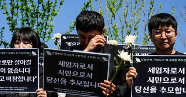 "Jeonse" real estate scam victims react at a rally near the National Assembly, during which signs were held that translate as "I pay tribute to you as a tenant and as a citizen," in tribute to the latest scam victim who killed themself, in Seoul, South Korea, May 8, 2024. (AFP Photo)