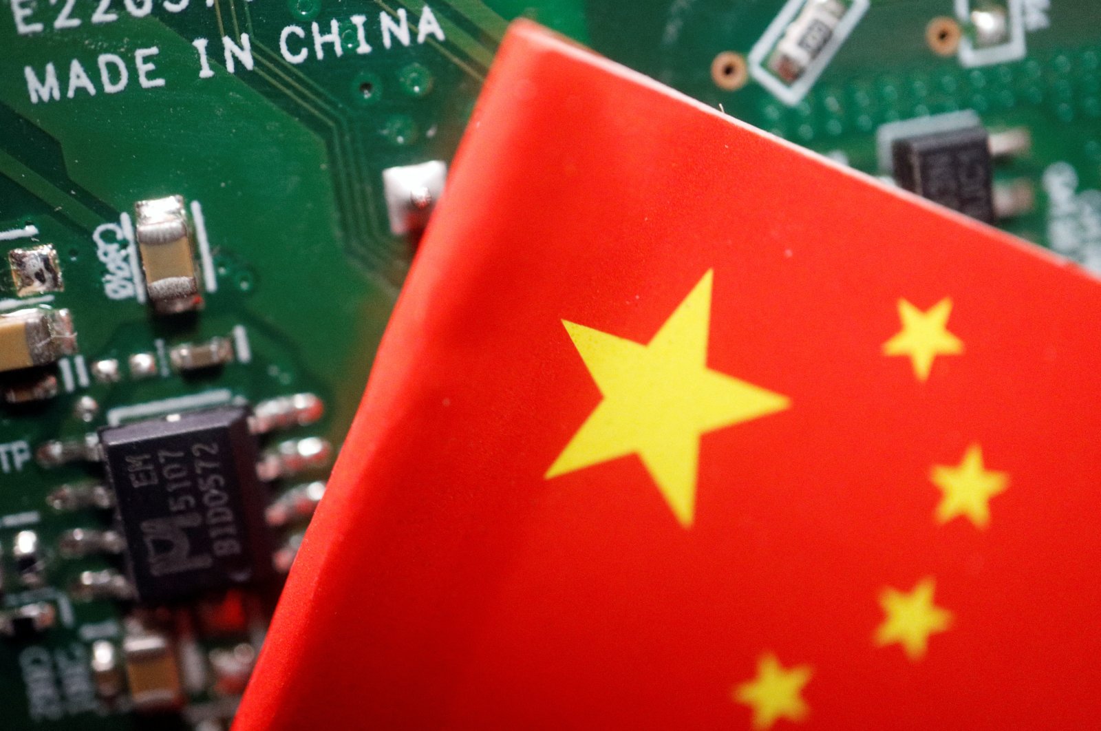 A Chinese flag is displayed next to a &quot;Made in China&quot; sign seen on a printed circuit board with semiconductor chips, in this illustration picture taken Feb. 17, 2023. (Reuters Photo)