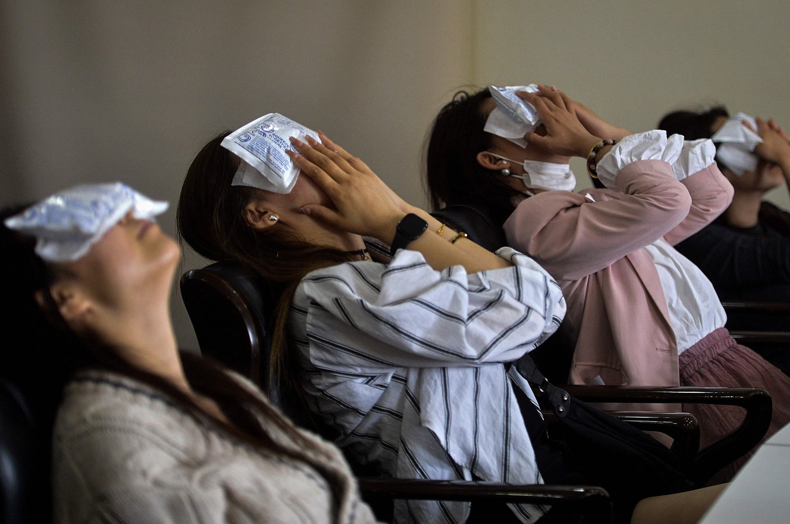 People using cold compresses on their eyes after undergoing cosmetic eyelid surgery at a hospital in Shenyang, northeastern Liaoning province, China, May 21, 2024. (AFP Photo)