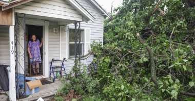 An elderly woman views storm damage from the front door of her home, in Claremore, Oklahoma, U.S., May 26, 2024. (AP Photo)