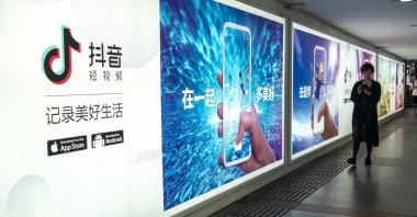 A pedestrian walks past an advertisement for the mobile app of Tik Tok, an overseas iteration of short video app Douyin, of Beijing Bytedance Technology Co. Ltd., Shanghai, China, July 6, 2018. (Reuters Photo)