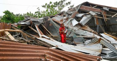 A girl walks amid her damaged house after cyclone Remal's landfall in Patuakhalim Bangladesh, May 28, 2024. (AFP Photo)