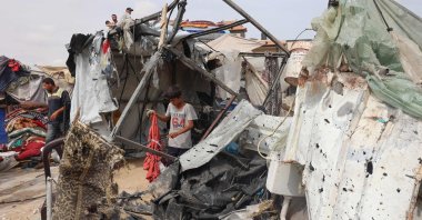 A Palestinian boy searches the debris at the site of an Israeli strike a day earlier on a camp for internally displaced people in Rafah, the southern Gaza Strip, Palestine, May 28, 2024. (AFP Photo)