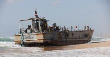 U.S. troops climb a beached vessel used for delivering aid to Palestinians via a new U.S.-built pier in Gaza, after it ran aground along with another aid vessel, on the Mediterranean shore in Ashdod, May 25, 2024. (Reuters Photo)