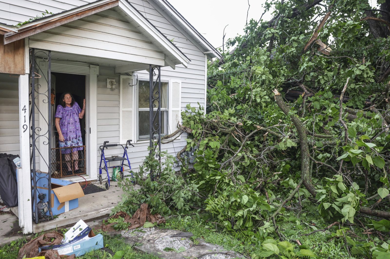 An elderly woman views storm damage from the front door of her home, in Claremore, Oklahoma, U.S., May 26, 2024. (AP Photo)