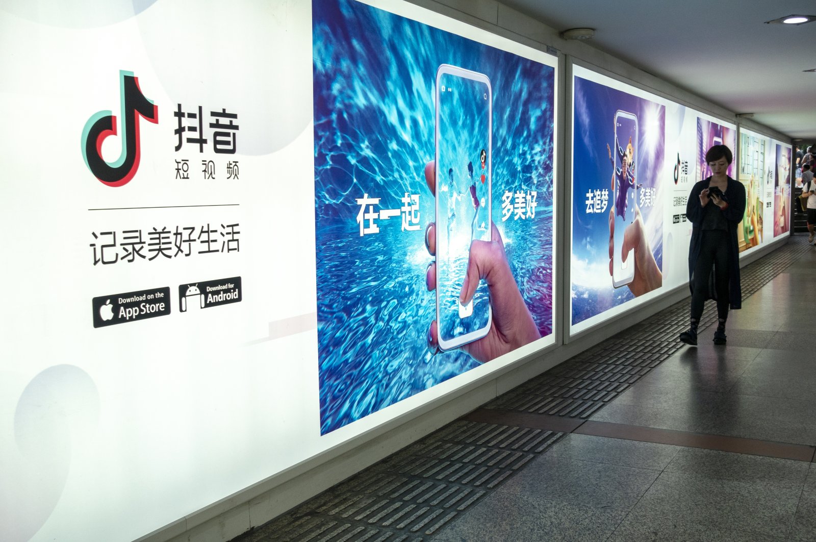 A pedestrian walks past an advertisement for the mobile app of Tik Tok, an overseas iteration of short video app Douyin, of Beijing Bytedance Technology Co. Ltd., Shanghai, China, July 6, 2018. (Reuters Photo)