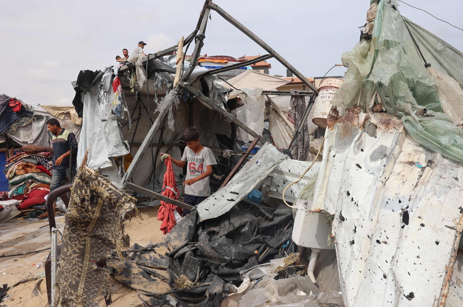 A Palestinian boy searches the debris at the site of an Israeli strike a day earlier on a camp for internally displaced people in Rafah, the southern Gaza Strip, Palestine, May 28, 2024. (AFP Photo)