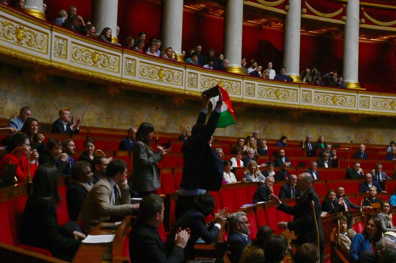 French leftist La France Insoumise (LFI) party member of parliament Sebastien Delogu waves a Palestinian national flag during a session of questions to the government at the National Assembly in Paris, May 28, 2024. (AFP Photo)