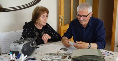 Cemil (R) and Kıymet Birtane, a couple forced to leave Bulgaria, browse old photos from their lives in Bulgaria, Kırklareli, northwestern Türkiye, May 29, 2024. (İHA Photo)