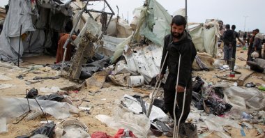 A man looks on as Palestinians inspect a tent camp damaged in an Israeli strike in Rafah, southern Gaza Strip, Palestine, May 28, 2024. (Reuters Photo)