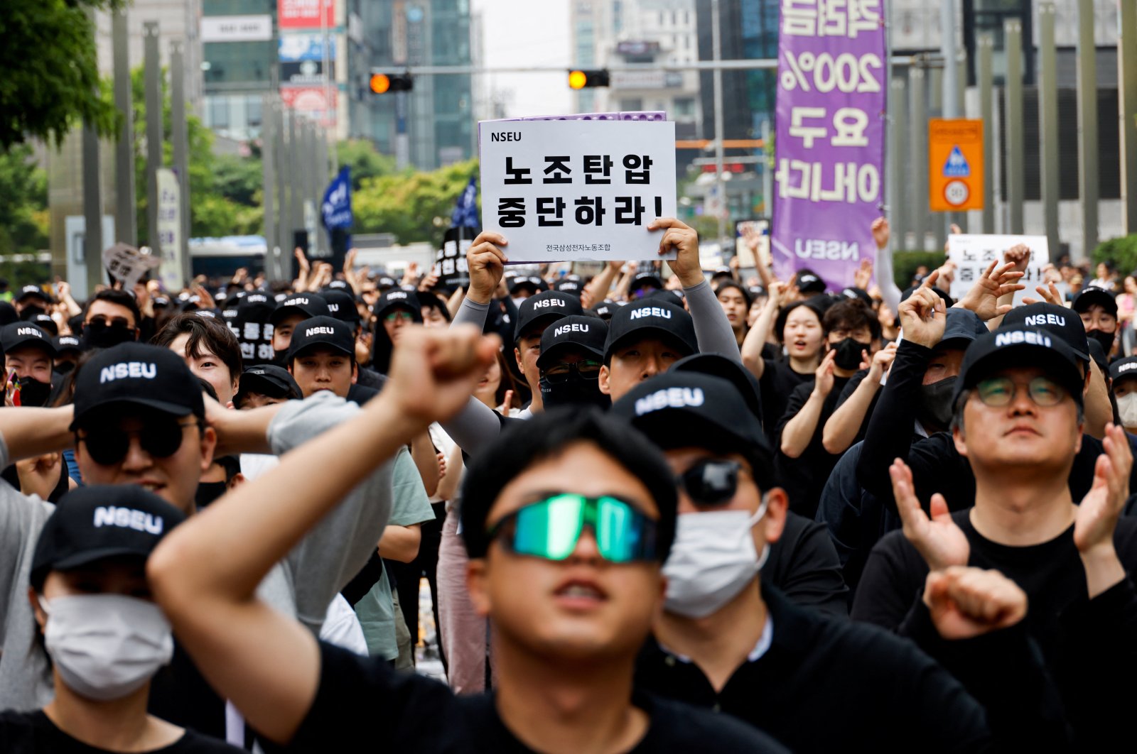 A member of the National Samsung Electronics Union (NSEU) holds a placard that reads &quot;Stop union busting&quot; in front of the Samsung Electronics Seocho Building in Seoul, South Korea, May 24, 2024. (Reuters Photo)