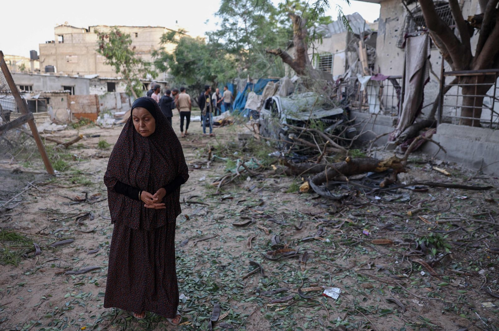  A Palestinian woman stands next to a damaged building after an Israeli airstrike in Rafah in the southern Gaza Strip on May 22, 2024. (AFP File Photo)