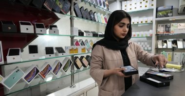 A cellphone vendor works at her shop in downtown Tehran, Iran, Feb. 21, 2024. (AP Photo)