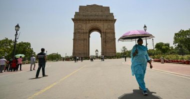 A woman holding an umbrella walks near the India Gate during a severe heatwave in New Delhi, India, May 29, 2024. (AFP Photo)