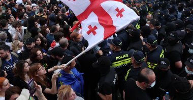 A woman waves a Georgian national flag as she protests the &quot;foreign influence&quot; law outside the parliament building in central Tbilisi, Georgia, May 28, 2024. (AFP Photo)