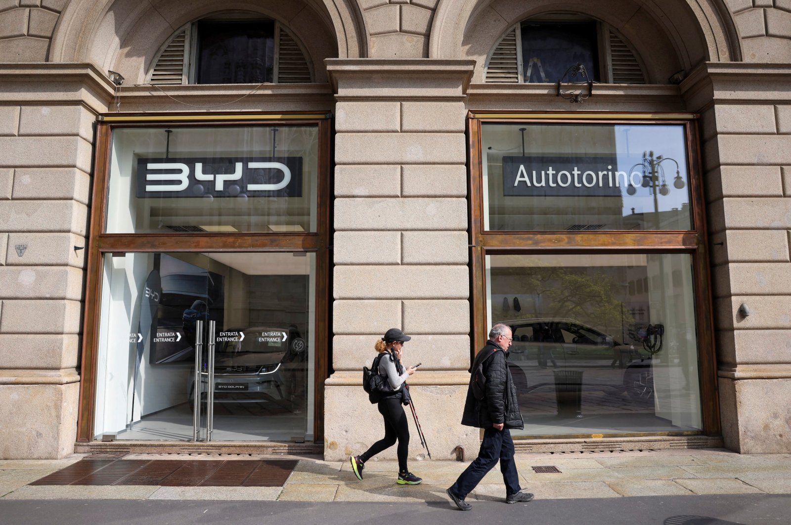 People walk in front of a BYD Auto and Autotorino store, Milan, Italy, March 20, 2024. (Reuters Photo)