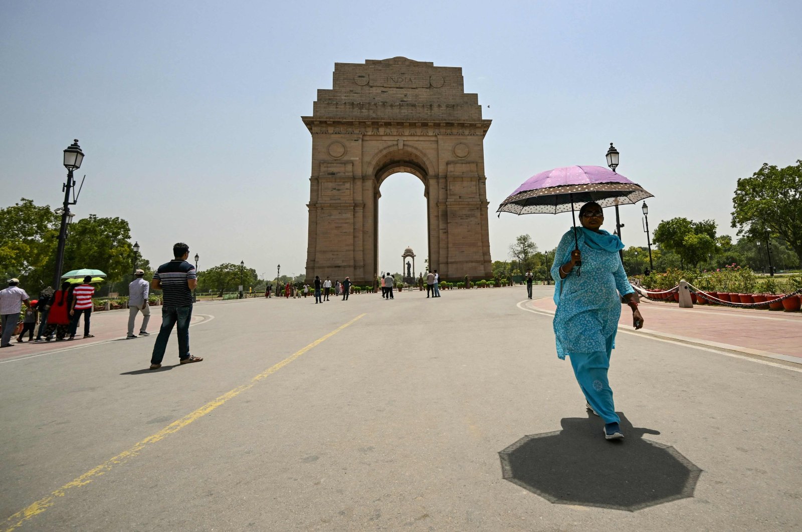 A woman holding an umbrella walks near the India Gate during a severe heatwave in New Delhi, India, May 29, 2024. (AFP Photo)