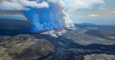  This handout picture released by the Icelandic Coast Guard shows billowing smoke and flowing lava pouring out of a new fissure, during a surveilance flight above a new volcanic eruption on the outskirts of the evacuated town of Grindavik, western Iceland, May 29, 2024. (AFP Photo)