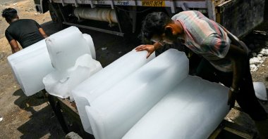 Workers stack ice blocks on a hand cart during a hot summer day in New Delhi, India, May 30, 2024. (AFP Photo)