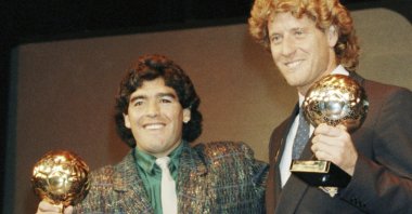 Argentina's Diego Maradona (L) and West German goalkeeper Harald Schumacher hold their World Cup Ball awards while posing with two young players during the Soccer Golden Shoe Award ceremony, Paris, France, Nov. 13, 1986. (AP Photo)