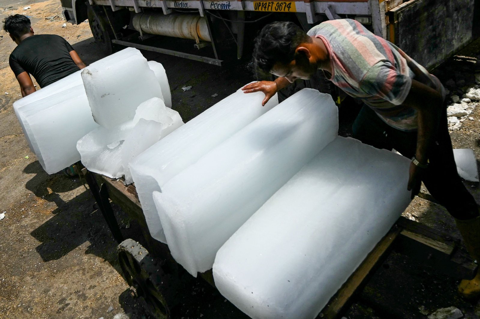 Workers stack ice blocks on a hand cart during a hot summer day in New Delhi, India, May 30, 2024. (AFP Photo)