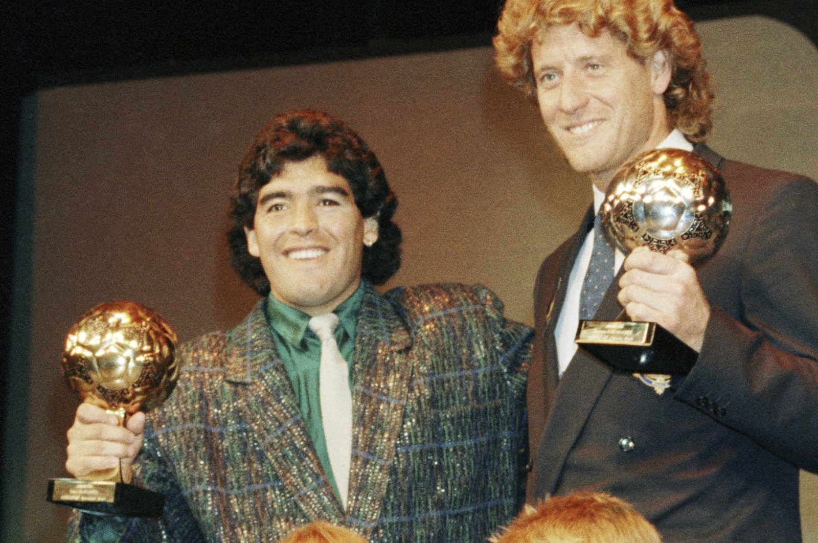 Argentina&#039;s Diego Maradona (L) and West German goalkeeper Harald Schumacher hold their World Cup Ball awards while posing with two young players during the Soccer Golden Shoe Award ceremony, Paris, France, Nov. 13, 1986. (AP Photo)