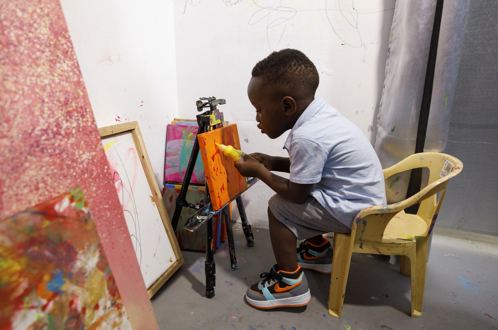 Ace-Liam Nana Sam Ankrah, who will turn 2 in July, paints at his mother&#039;s art gallery in Accra, Ghana, May 27, 2024. (AP Photo)