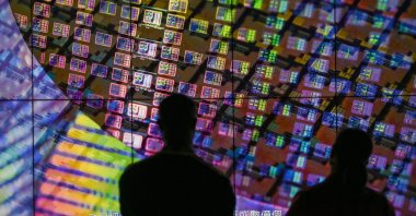 Visitors watch a wafer shown on screens at the Taiwan Semiconductor Manufacturing Company (TSMC) Renovation Museum at the Hsinchu Science Park in Hsinchu, Taiwan, July 5, 2023. (AFP Photo)