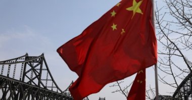 A Chinese national flag flutters near the Friendship Bridge and Broken Bridge over the Yalu River, which separates North Korea's Sinuiju from China, in Dandong, Liaoning province, China, April 21, 2021. (Reuters Photo)
