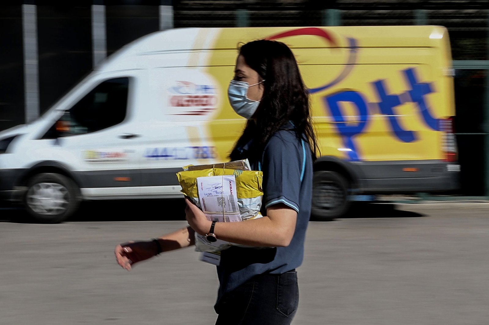 A PTT employee walks in front of a postal service vehicle in Turkish capital Ankara&#039;s Yenimahalle district, Ankara, Türkiye, Oct. 9, 2021. (AA Photo)