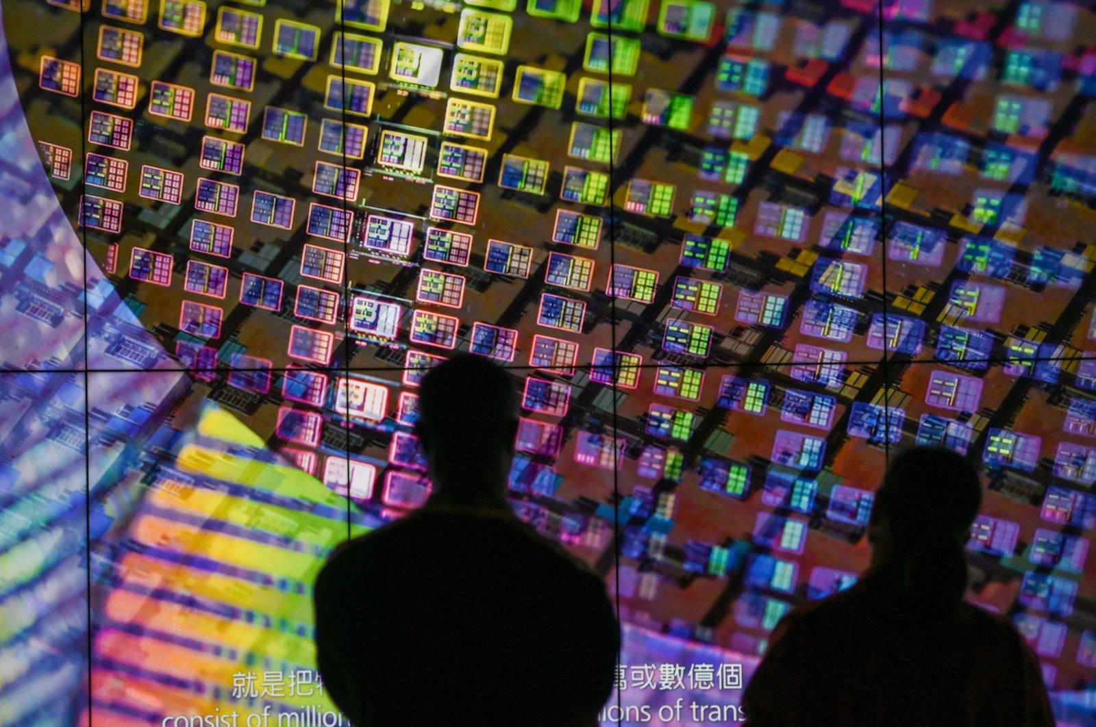 Visitors watch a wafer shown on screens at the Taiwan Semiconductor Manufacturing Company (TSMC) Renovation Museum at the Hsinchu Science Park in Hsinchu, Taiwan, July 5, 2023. (AFP Photo)