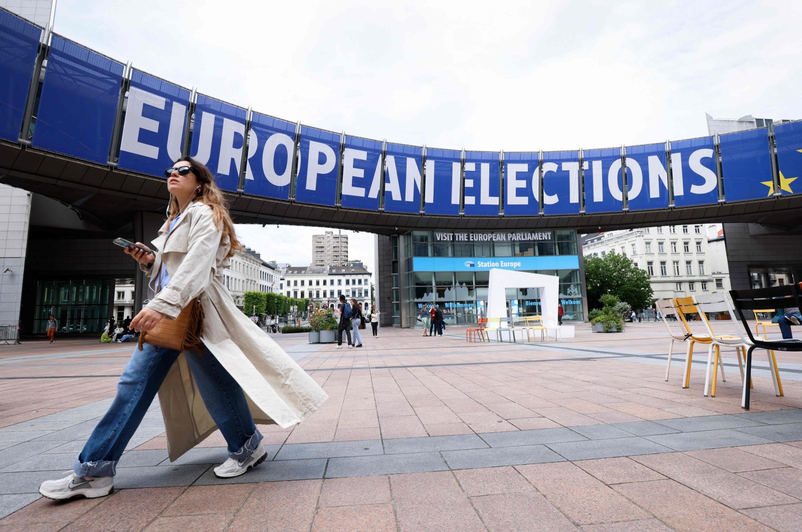 A pedestrian walks past a banner displayed on the building of the European Parliament in Brussels ahead of the European elections, Belgium, May 17, 2024. (AFP Photo)