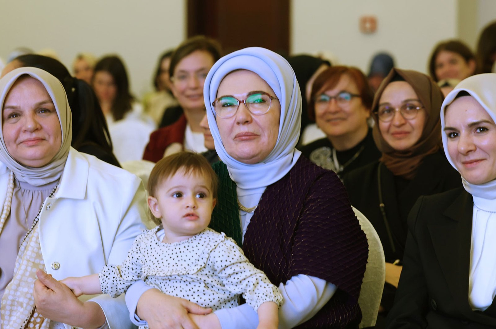 First lady Emine Erdoğan (C) poses with a toddler during a meeting with female members and lawmakers of the ruling Justice and Development Party (AK Party), Ankara, Türkiye, June 2, 2024. (AA Photo)