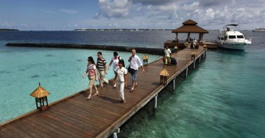 Foreign tourists arrive in a resort in the Kurumba island in Maldives, Feb. 12, 2012. (AP Photo)