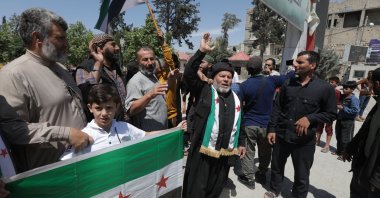 Protesters hold a flag of the Syrian opposition as they condemn the PKK/YPG terrorists&#039; planned "elections" in northern Syria, May 31, 2024. (AA Photo)