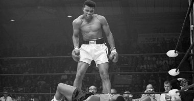 Heavyweight champion Muhammad Ali stands over Sonny Liston and taunts him to get up during their title fight at the Central Maine Youth Center, Lewiston, Maine, U.S., May 25, 1965. (Getty Images Photo)