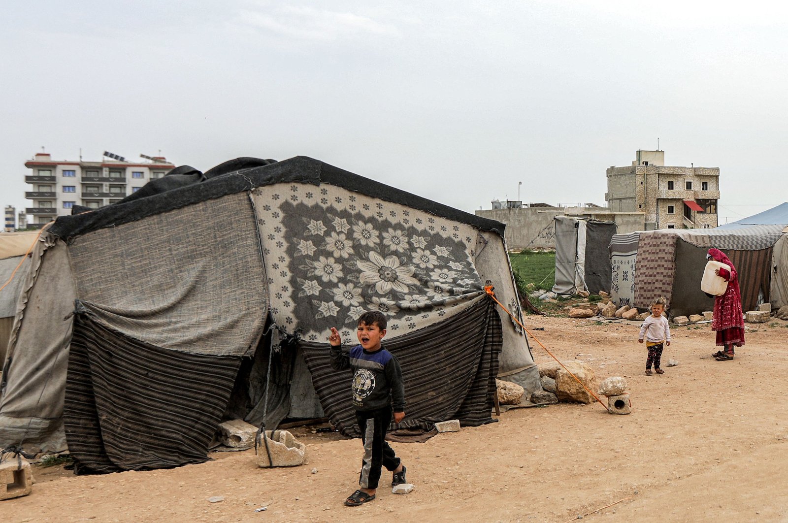 A boy walks past a tent at a camp for people displaced by conflict in northern Aleppo province, Syria, April 26, 2024. (AFP Photo)