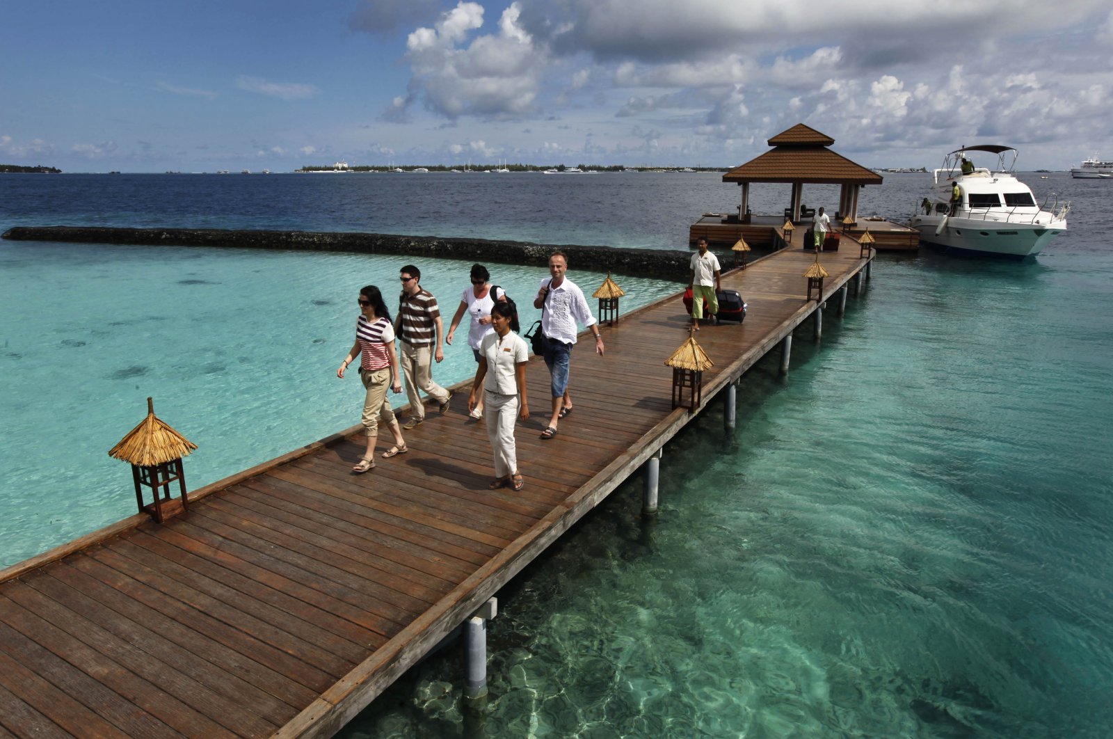 Foreign tourists arrive in a resort in the Kurumba island in Maldives, Feb. 12, 2012. (AP Photo)