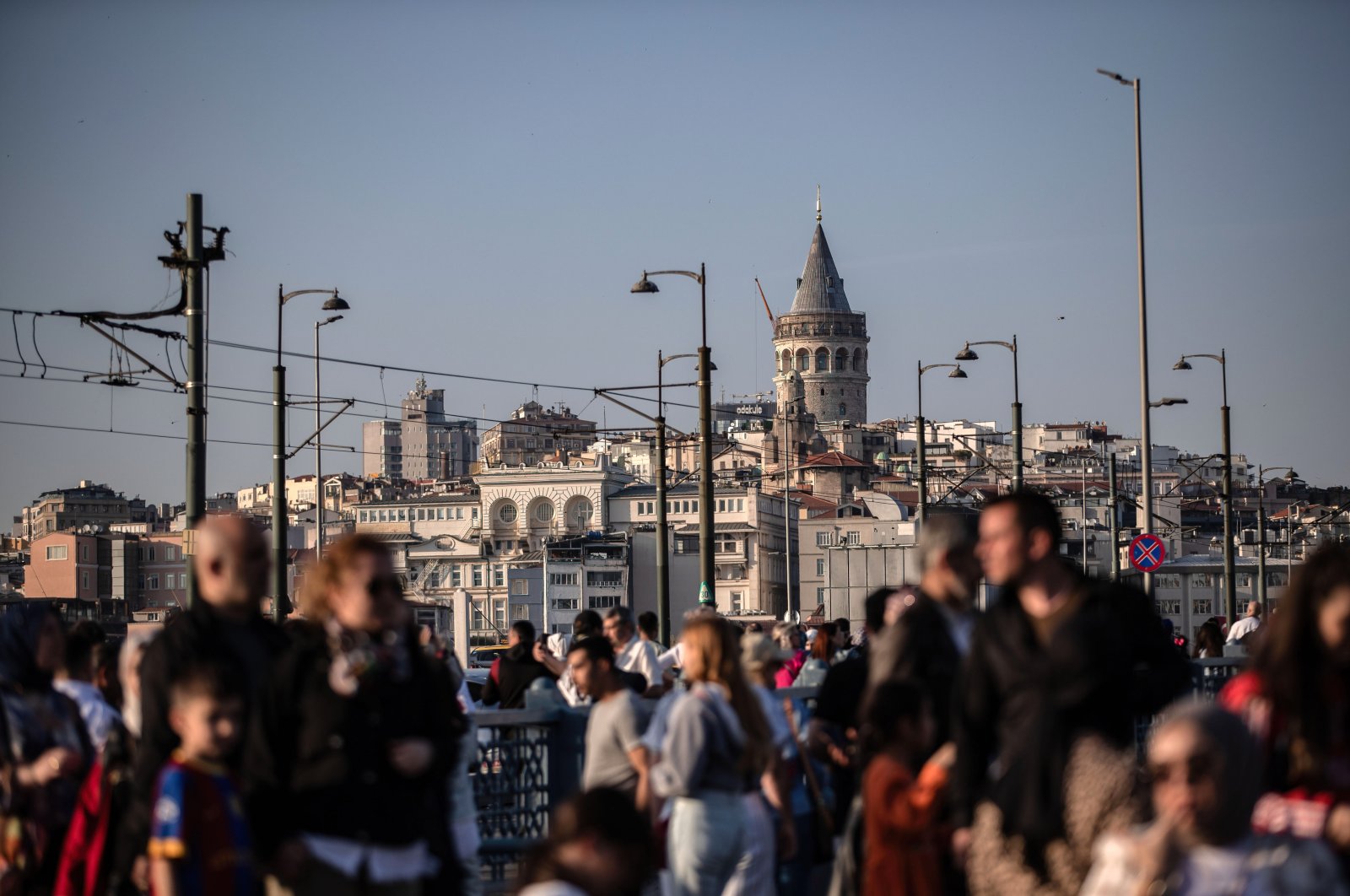 People walk on the Galata Bridge, with the Galata Tower seen in the background, June 3, 2024. (Reuters Photo)