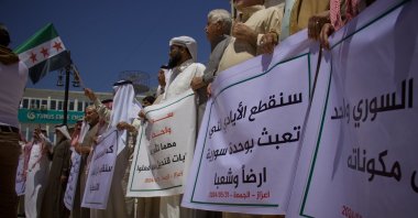Protesters hold placards condemning PKK/YPG terrorists&#039; planned "elections" in northern Syria, May 31, 2024. (AA Photo)