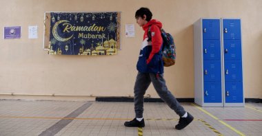 A middle school student walks in a hallway near a banner that says "Happy Ramadan" at the Averroes school, in Lille, France, March 19, 2024. (Reuters Photo)