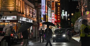 People walk down a street filled with restaurants and bars on a rainy evening in the entertainment area of Akasaka-Mitsuke in Tokyo, Japan, May 13, 2024. (AFP Photo)