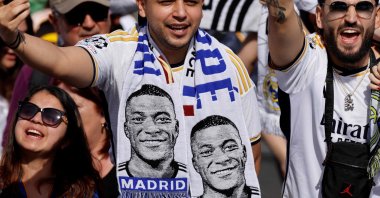 Supporters wearing football scarves depicting French footballer Kylian Mbappe cheer prior Real Madrid&#039;s celebration for winning 2024 Spanish La Liga title at Cibeles square, Madrid, Spain, May 12, 2024. (AFP Photo)