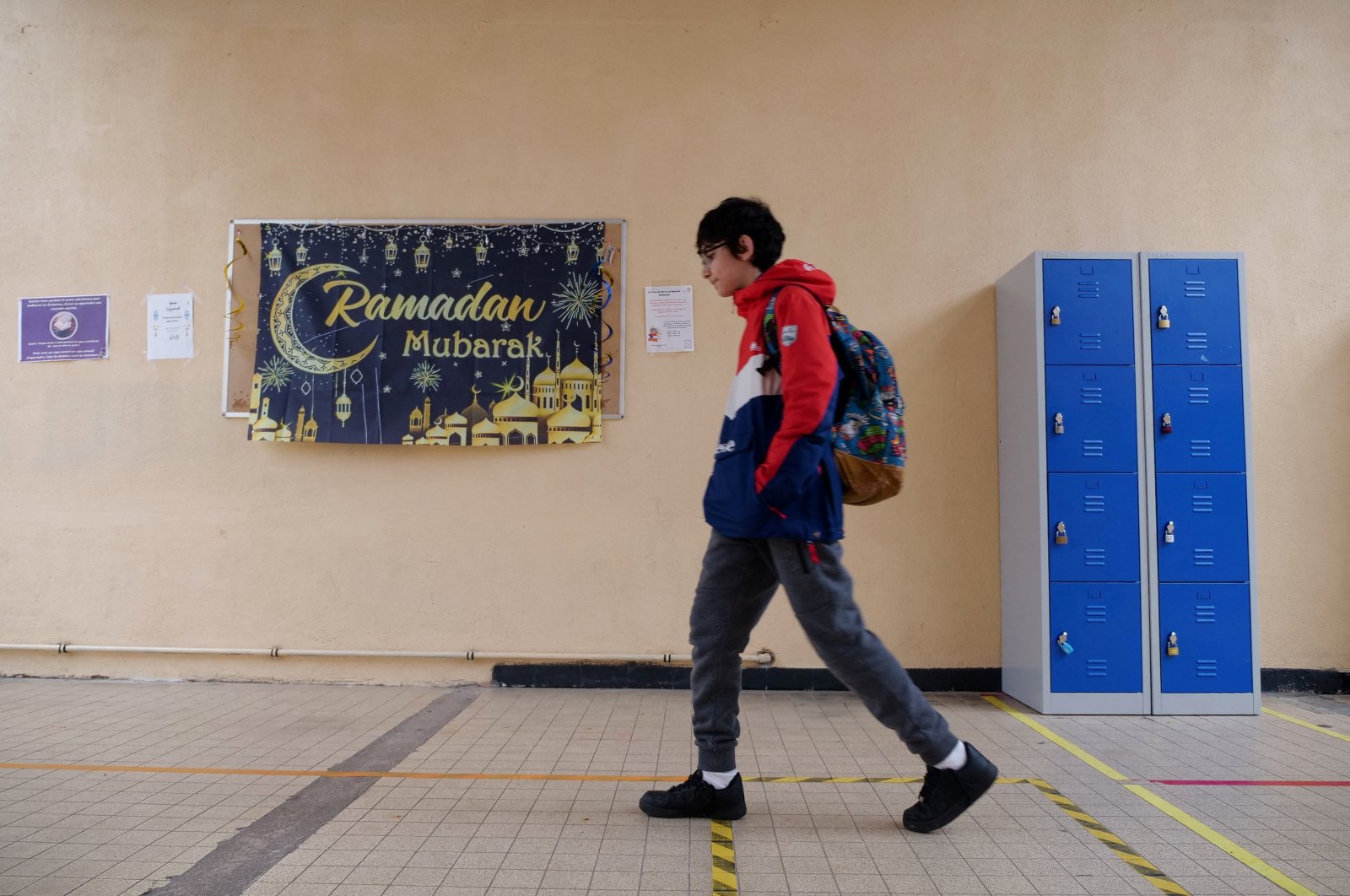 A middle school student walks in a hallway near a banner that says "Happy Ramadan" at the Averroes school, in Lille, France, March 19, 2024. (Reuters Photo)